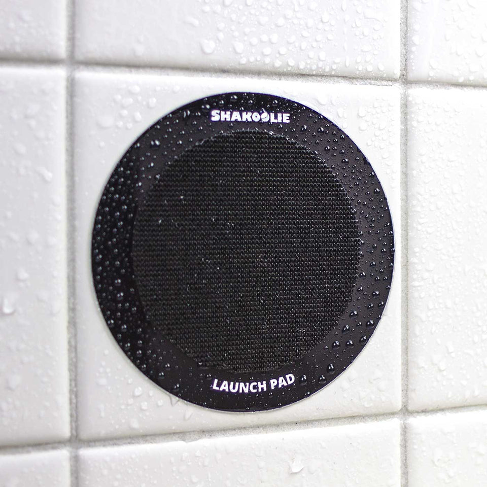 Photo of "The Launch Pad" which is a thick vinyl sticker with industrial velcro that holds the foam can beverage holder on your shower wall.