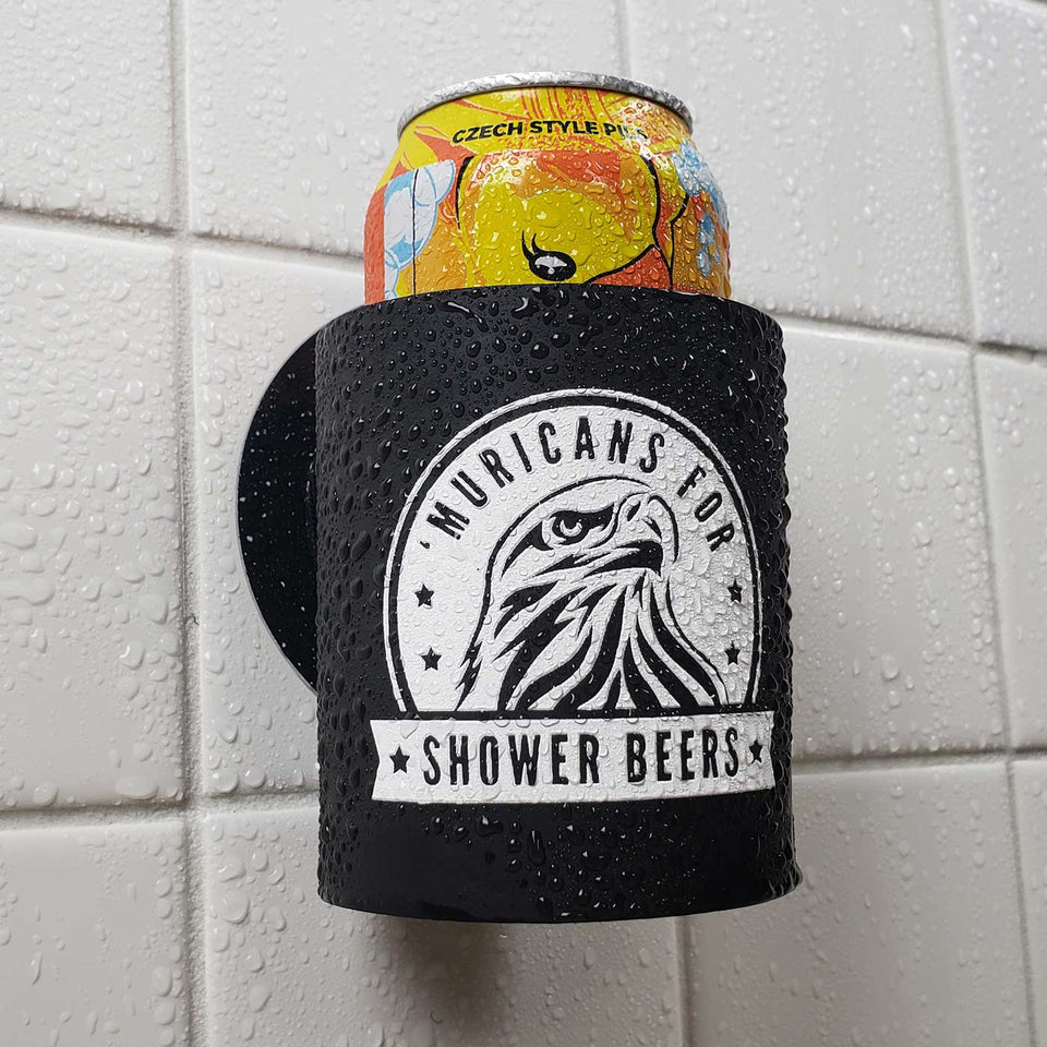 Foam can beverage holder that sticks to shower wall via industrial velcro. This design is white ink printed on a black can holder with the words "Muricans For Shower Beers" written with artwork depicting a beautiful bald eagle.. This is an action shot of the product in a shower.